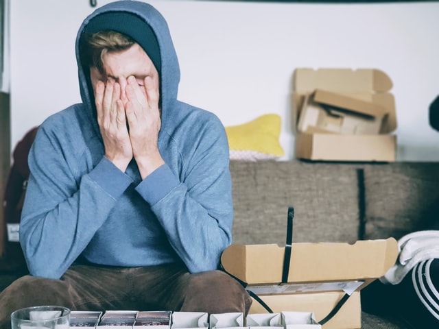 Man holding his hands up to his face feeling anxious